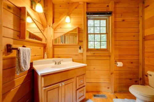 y baño con lavabo y aseo. en Exquisite Cabin with Deck and Fire Pit, 10 Mi to Lake, en Athol