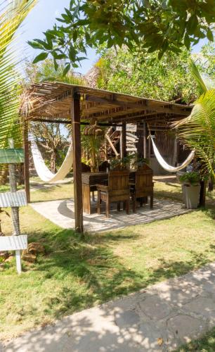 a wooden gazebo with a hammock in a park at Kite Eco House Salinas del rey in Salina de Rey
