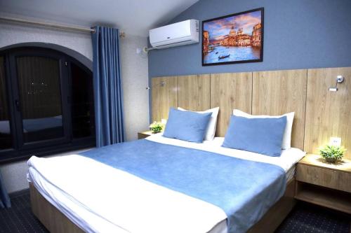 1 Schlafzimmer mit 2 Betten und blauen Kissen in der Unterkunft Apple Hotel 小苹果酒店 FREE Airport Service in Taschkent