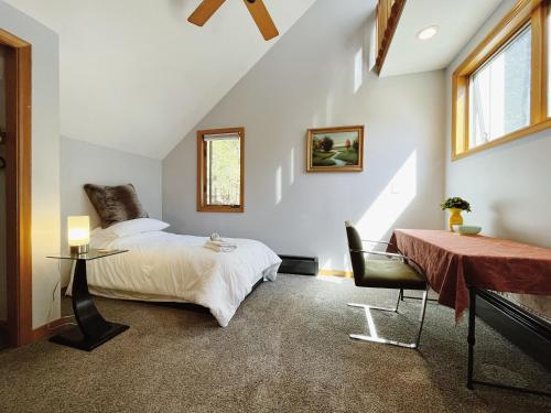 1 dormitorio en el ático con cama, mesa y sidra de mesa en Sunny Peace en Harwinton