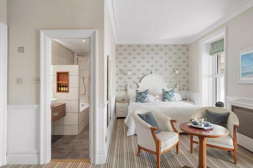 a bedroom with a bed and a table and a chair at Watersmeet Hotel in Woolacombe