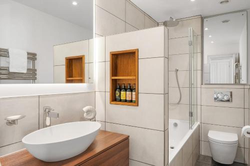 a white bathroom with a tub and a shower at Watersmeet Hotel in Woolacombe
