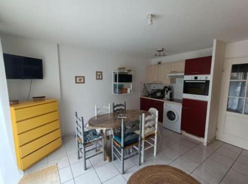 une cuisine et une salle à manger avec une table et des chaises dans l'établissement Charmant studio en bord de mer, à Camiers