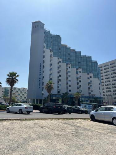 un gran edificio con coches estacionados en un estacionamiento en Sima Suite 2, en Ashdod