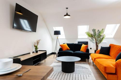 a living room with orange and black furniture at The Berriman Collection Stylish Sleeps 6 - 2 Bedroom in Cardiff
