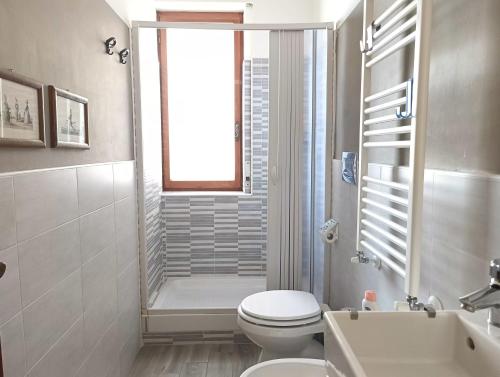 ein Bad mit einem WC, einem Waschbecken und einem Fenster in der Unterkunft Bilocale in Centro a Pescara in Pescara