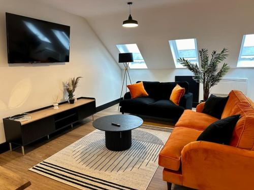 a living room with two couches and a flat screen tv at The Berriman Collection Stylish Sleeps 6 - 2 Bedroom in Cardiff