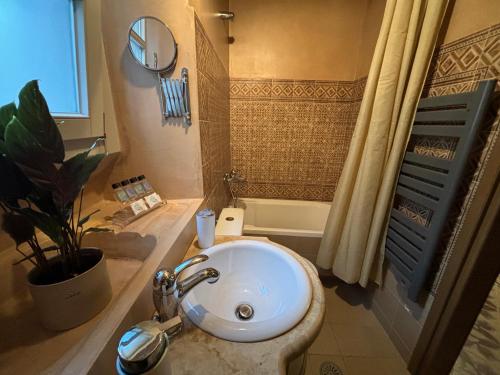 uma casa de banho com um lavatório branco e um chuveiro em Irene's Mansion em Vrontádos