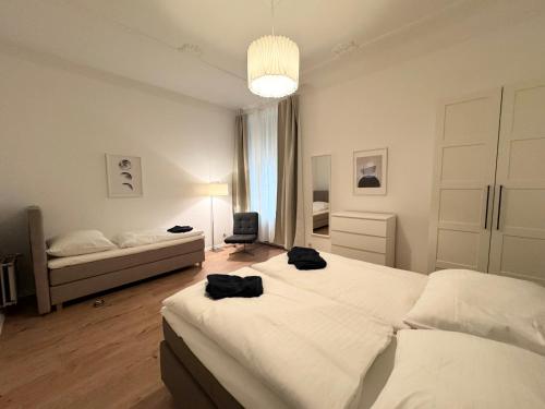 a bedroom with two beds and a chair in it at Be in Berlin Apartments at Charlottenburg Castle in Berlin