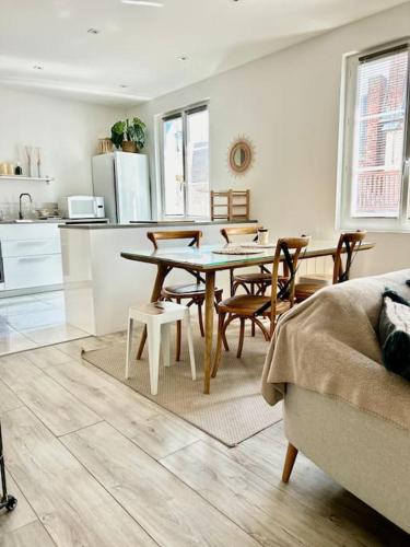 une cuisine et une salle à manger avec une table et des chaises dans l'établissement Voyage à la plage, à Deauville