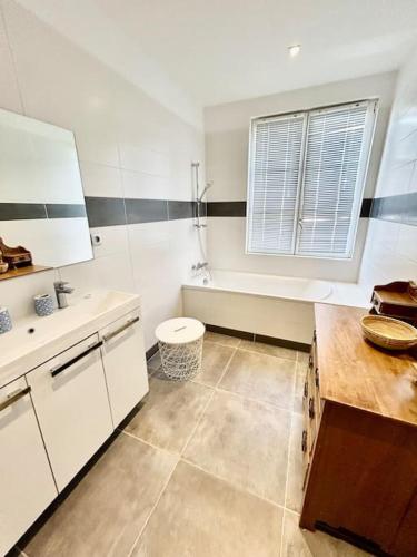 une salle de bain blanche avec des toilettes et un lavabo dans l'établissement Voyage à la plage, à Deauville