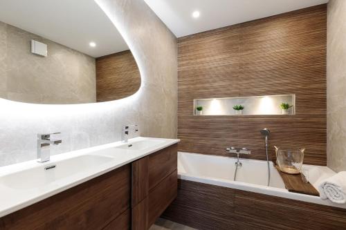 y baño con lavabo, bañera y espejo. en Spacieux appartement de 114 m2 à 5 min des plages - proximité tous commerces et transports, en Antibes