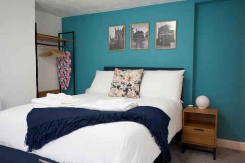 una camera da letto con una parete blu e un letto di Garden Apartment by Kahuna Stays 