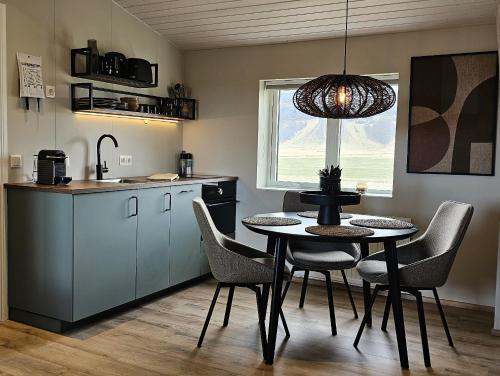 - une cuisine et une salle à manger avec une table et des chaises dans l'établissement Kviholmi Premium Apartments, à Hvolsvöllur