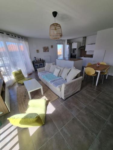 un salon avec un canapé et une cuisine dans l'établissement Appartement Villa Trencat, à Biscarrosse