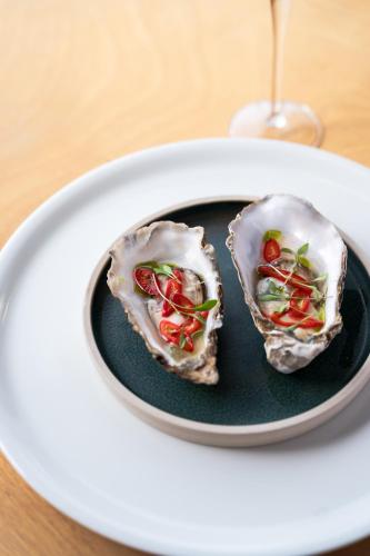 two oysters on a plate with a glass of wine at Watersmeet Hotel in Woolacombe