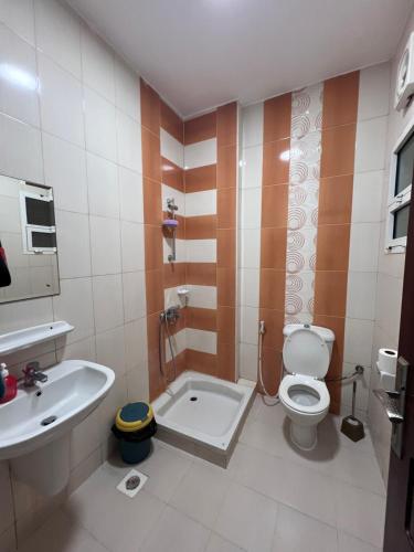 een badkamer met een toilet en een wastafel bij Blue Umbrella in Muscat