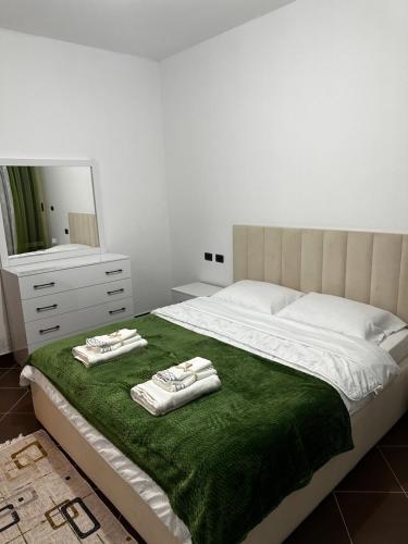 sypialnia z dużym łóżkiem z dwoma ręcznikami w obiekcie Iri Apartment w Durrës