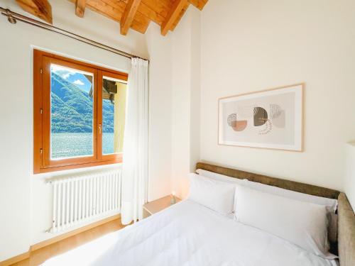 um quarto com uma cama e uma janela em Villa Luminosa Laglio - Private Parking, Garden em Laglio