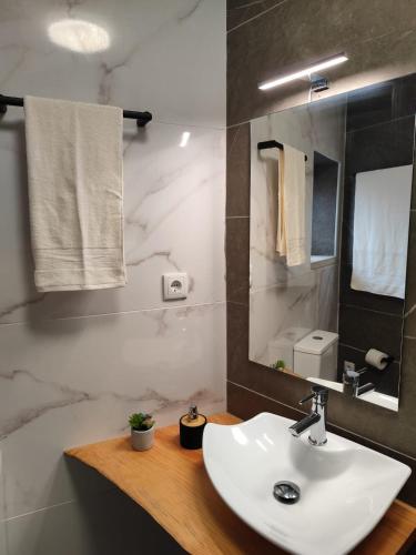 a bathroom with a white sink and a mirror at Casa do Canastro in Mondim de Basto