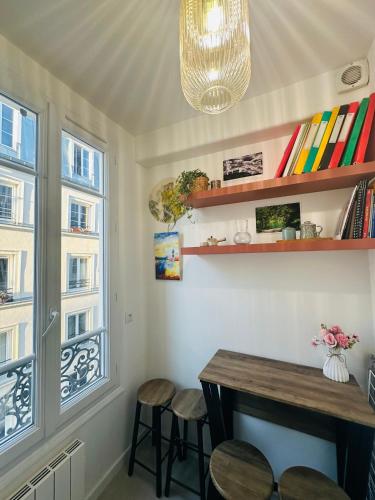 une pièce avec une table, des chaises et une fenêtre dans l'établissement Dream Dwell Paris-artist flat 450m to Mont Martre, à Paris