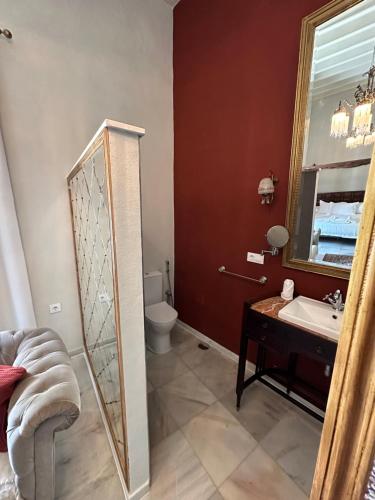 W łazience znajduje się lustro, umywalka i toaleta. w obiekcie Casa Jaramago w mieście Jerez de la Frontera