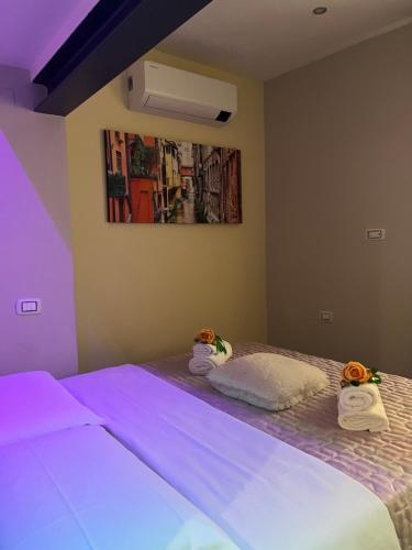 a bedroom with two beds with purple lights at BolognaBySide-DE FALEGNAMI in Bologna