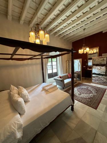 ein Schlafzimmer mit einem Himmelbett und ein Wohnzimmer in der Unterkunft Casa Jaramago in Jerez de la Frontera