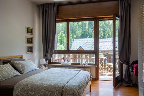 a bedroom with a bed and a large window at La Casa di Carmen in Tarvisio