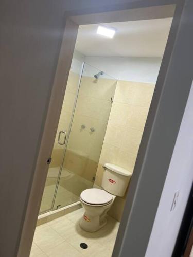 a bathroom with a toilet and a glass shower at acogedor apartamento zona este barquisimeto in Santa Elena
