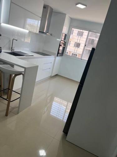 a white kitchen with a sink and a counter at acogedor apartamento zona este barquisimeto in Santa Elena