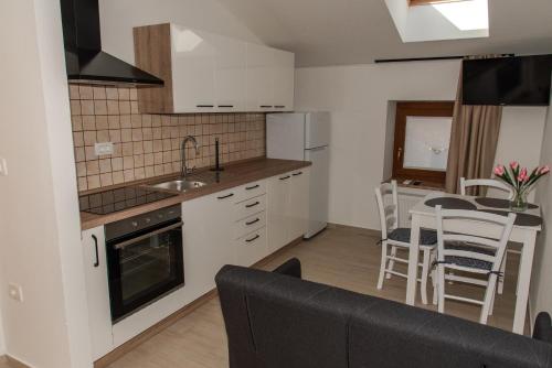 a kitchen and living room with a table and chairs at Apartmaji Tinta in Kanal