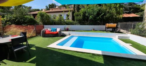 une piscine dans une cour avec une table et des chaises dans l'établissement Location au cœur de la Provence, à Lamanon