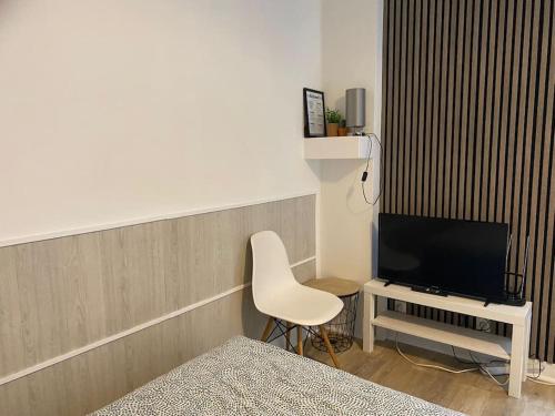een kamer met een bed, een tv en een stoel bij Modern studio - Le Bourget Ideal JO 2024 in Le Bourget
