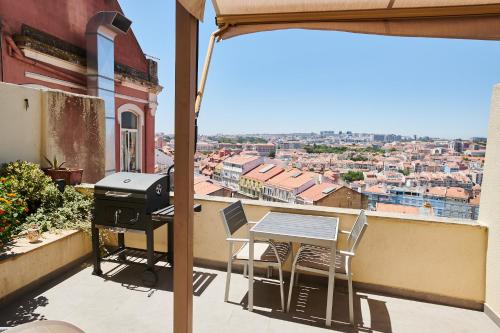 a balcony with a grill and a table and chairs at The Sunset Hideout in Lisbon