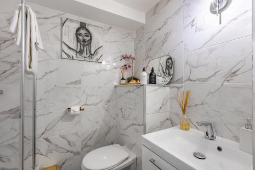 une salle de bain blanche avec des toilettes et un lavabo dans l'établissement Romanctic Loft near Eiffel Tower, à Paris