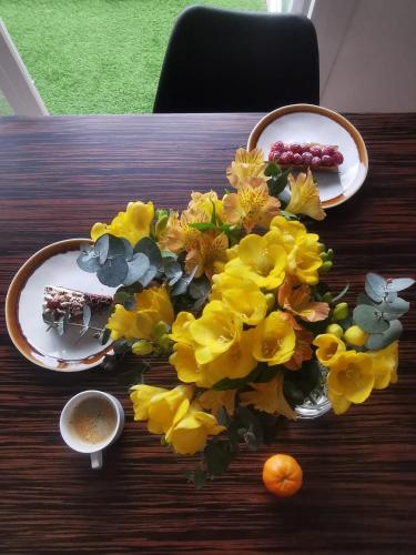 un bouquet de fleurs jaunes sur une table en bois dans l'établissement Appartement 3 pièces à seulement 5km de Paris - for 2 to 7 Guests !, à Fontenay-aux-Roses