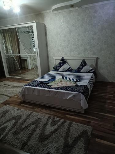 een slaapkamer met 2 bedden en een spiegel bij Квартира in Taraz