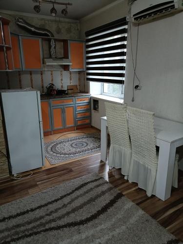 een keuken met een tafel en stoelen in een kamer bij Квартира in Taraz