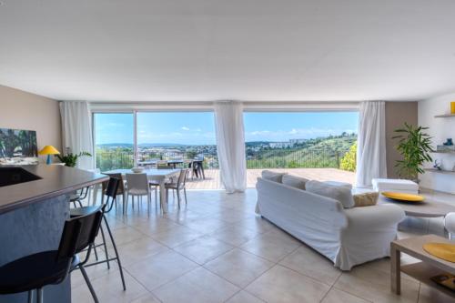 un salon avec des meubles blancs et une grande fenêtre dans l'établissement Villa d'architecte Parfaite pour les vacances !, à Montpellier