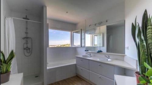 La salle de bains est pourvue de 2 lavabos, d'une douche et d'une baignoire. dans l'établissement Villa d'architecte Parfaite pour les vacances !, à Montpellier
