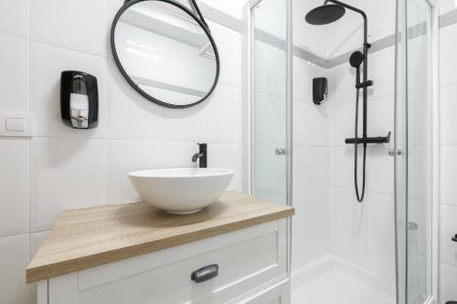 a bathroom with a white sink and a mirror at Mahalo Home in Porriño