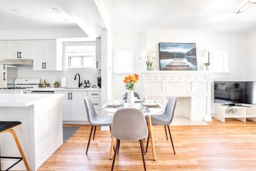 a white kitchen with a table and chairs at 3BR Luxury Home - Heart of St Clair West in Toronto