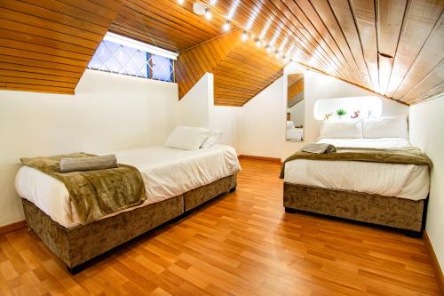 - 2 lits dans une chambre dotée de parquet dans l'établissement Brand New Huge 400 square Colonial House Wooden Accent in Upperclass North Side Bogota, à Bogotá