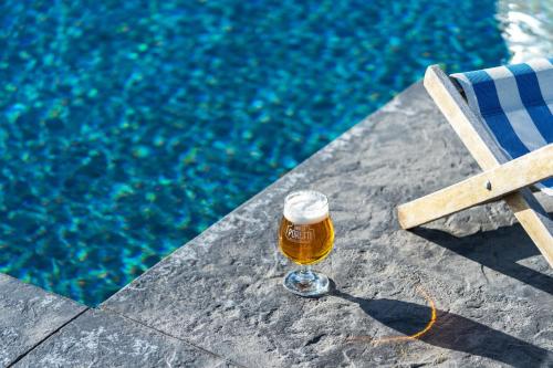 a glass of beer sitting next to a swimming pool at Watersmeet Hotel in Woolacombe