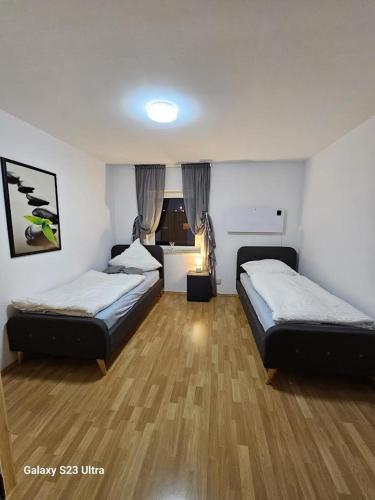 a room with two beds in a room with wooden floors at M&L Wohnen 2 in Essen