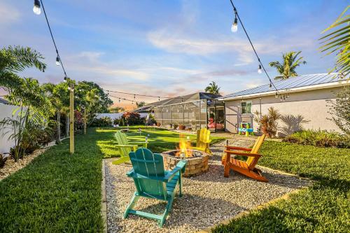 a backyard with chairs and a fire pit at Entertainers Paradise with HTD Pool & Putting Green in Cape Coral