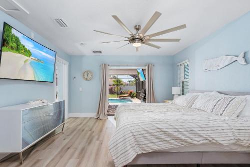 a bedroom with a bed and a flat screen tv at Entertainers Paradise with HTD Pool & Putting Green in Cape Coral