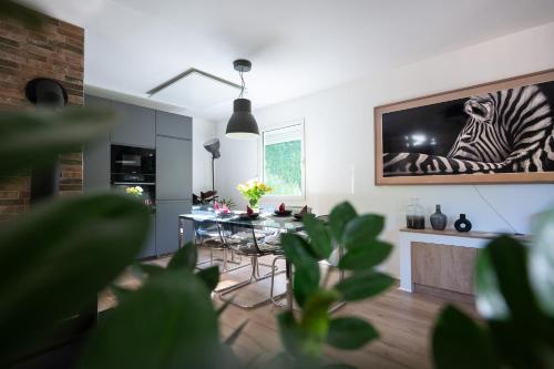 a living room with a table with a zebra picture on the wall at Hiša Juliana - Your Escape From Massive Tourism in Podbrdo