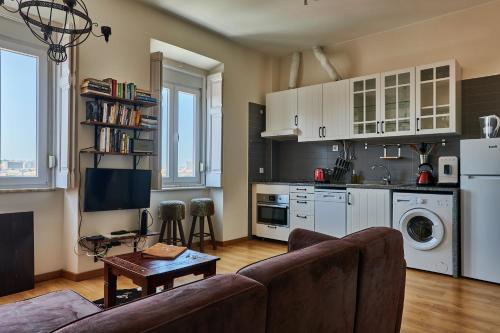 a living room with a couch and a kitchen at The Hilltop Nest in Lisbon